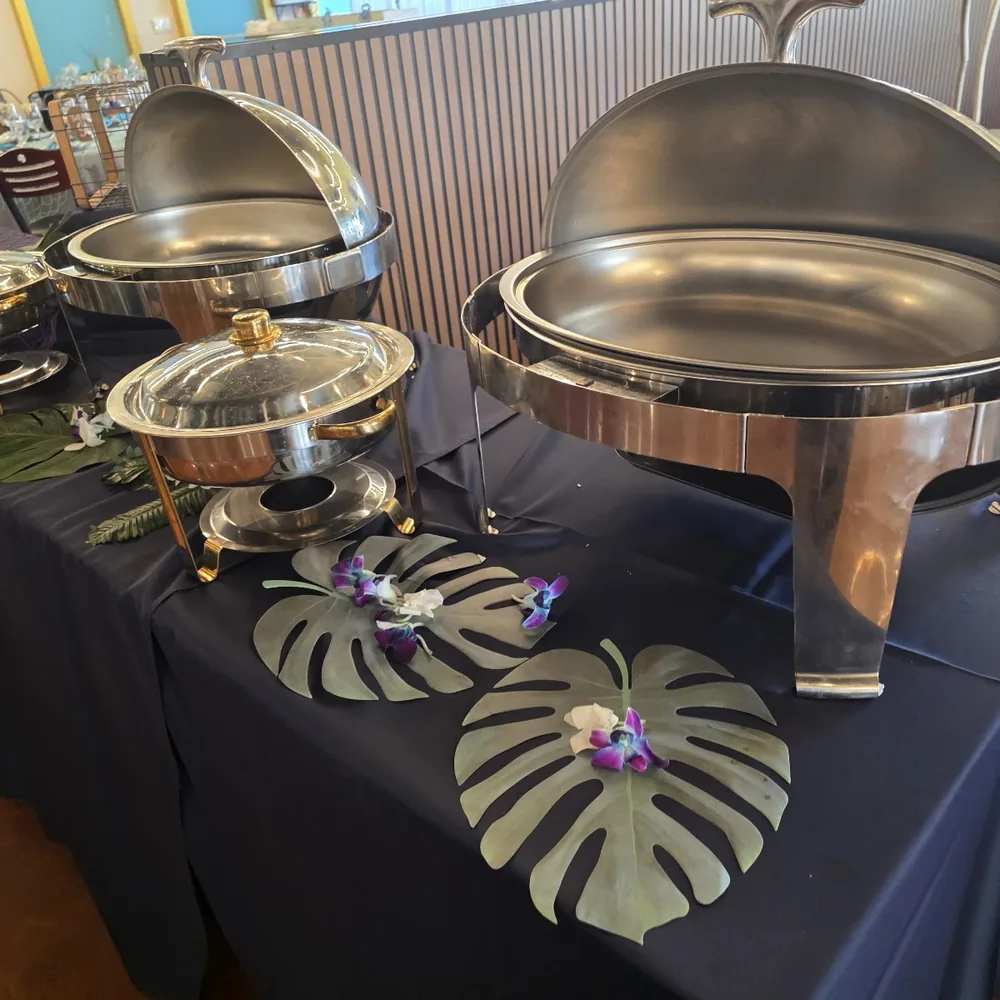 A buffet table dressed with monstera leaves for a private event